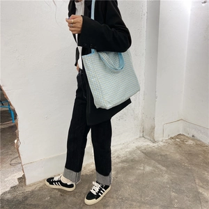 Detalle de bolso de lona a cuadros azul claro con correas dobles para uso casual diario