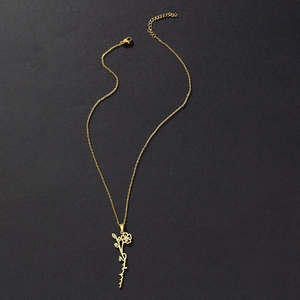 Detailed close-up of golden stainless steel flower pendant with cursive Arabic script