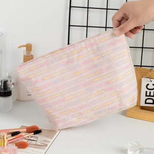 Detail of pink woven large capacity makeup bag with multi-color textured fabric