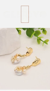 Detail of baroque pearl drop earrings with 18k gold plating and amber crystal beads
