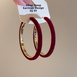 Detail of red velvet and gold metal hoop earrings featuring anti-allergic silver needles