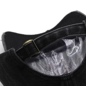 Detail of vintage washed black cotton baseball cap with adjustable antique brass buckle
