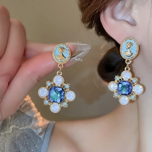 Détail de boucles d'oreilles vintage avec camée bleu et pendentif en pierre facettée