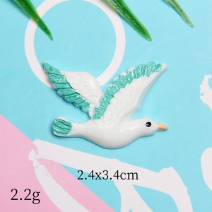 Detail of seagull resin charm with green wings for DIY hair clips and crafts
