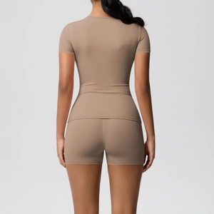 Rear view of tight-fit yoga set showing seamless earth-toned short sleeve top and gym shorts
