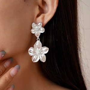 Close-up of model wearing silver flower petal earrings with metallic texture and minimalist style