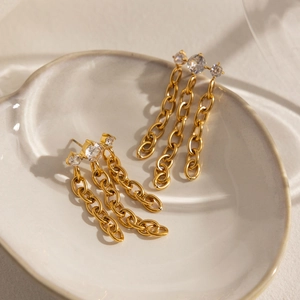 Détail de boucles d'oreilles pompons en or 18 carats avec des zircons scintillants
