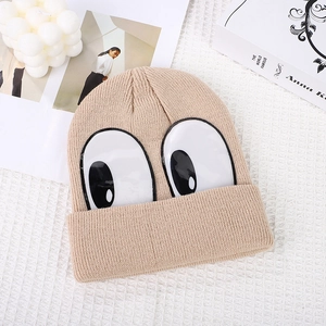 Detailed knit of khaki beanie with cute cartoon eyes decoration on waffle cloth