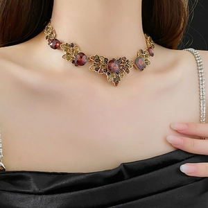Macro shot of vintage gold-tone floral necklace with red and green rhinestones
