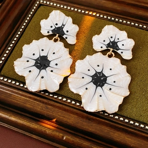 Détail des boucles d'oreilles feuille de ginkgo vintage avec émail blanc et noir