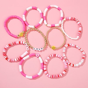 Detail view of a 9-piece pink and red beaded bracelet set with LOVE charms and hearts