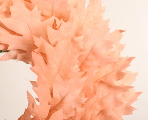 Macro detail of peach pink faux silk leaves with realistic vein textures on a wreath