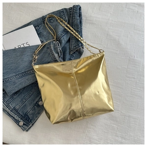 Detail of golden metallic PU tote bag showing vertical stitching and chain strap