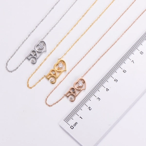 Detailed view of 520 heart necklaces in gold and silver with scale for size measurement