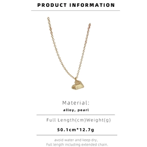Detail view of heart pendant with faceted texture, gold alloy, pearl and sizing details