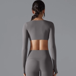 Vista posteriore di crop top yoga aderente con fori per i pollici e leggings grigio scuro