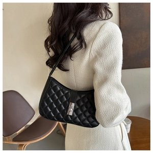Détail du sac à bandoulière matelassé noir avec fermoir en métal argenté et cuir lisse