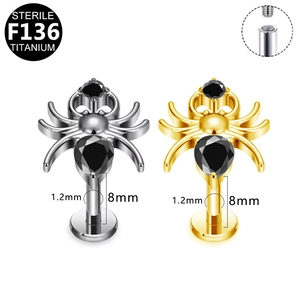 Macro detail of F136 titanium spider labret studs with internal thread and black gems