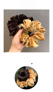 Detail van fluwelen scrunchies in bruin en goud met elastische plooistructuur