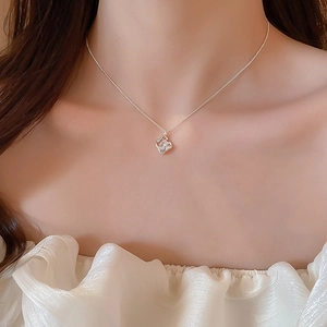 Detailed close-up of 18k gold plated hollow square necklace on model's neck