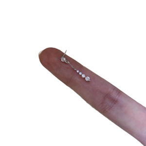 Minimalist silver dangle earrings with sparkling zircon crystals shown on a finger
