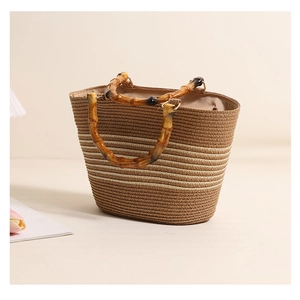 Close-up of natural bamboo handle and striped woven texture on brown straw handbag