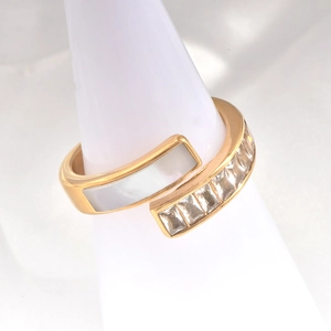 Detail shot of a gold 18k titanium steel open ring with white shell and zircon settings