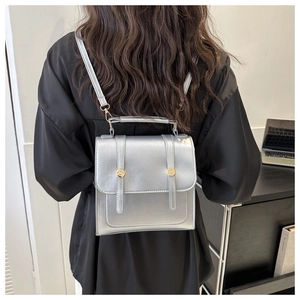 Sac à dos en cuir PU argenté avec boucles porté par un mannequin dans un bureau