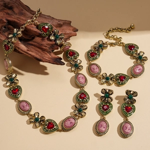 Vintage gold jewelry set featuring pink cameo pendants with red and green crystals