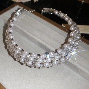 Close-up of triple-layer pearl and rhinestone bow choker in a velvet jewelry box