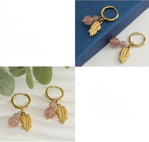 Polished gold feather earring detail with pink natural stone and 18K plating texture