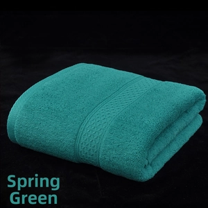 Detail of spring green cotton bath towel showing thick looped texture and woven border