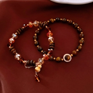 Détail du lot de bracelets en œil de tigre avec pendentif gourde dorée sur soie rouge