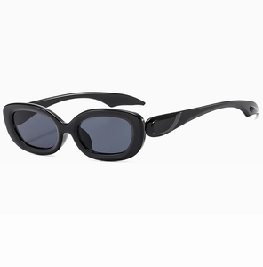 Detail of vintage black oval sunglasses featuring thick glossy frames and wide temple arms