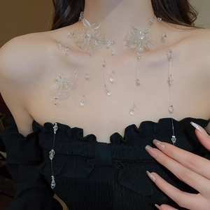 Detail of transparent floral necklace with cascading crystal tassels on a model