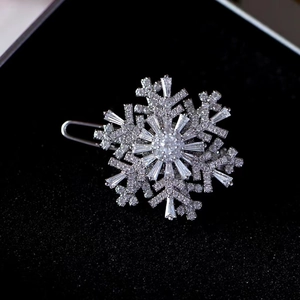 Elegant rotating snowflake brooch with sparkling cubic zirconia on a dark background