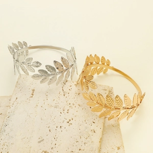 Minimalist leaf open cuff bracelet in gold and silver finish on stone background