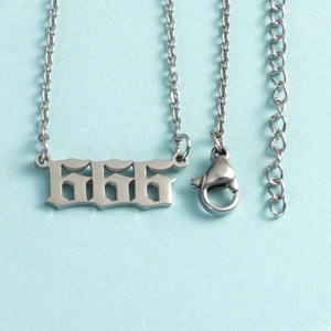 Macro shot of silver gothic 666 number pendant on stainless steel necklace chain