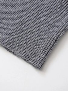 Macro close-up showing the detailed grey vertical rib knit texture of the sweater fabric