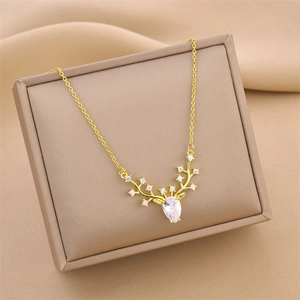 Golden reindeer antler pendant necklace with teardrop crystal on jewelry gift box
