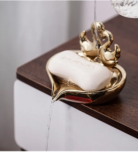 Detail of golden swan ceramic soap dish showing the self-draining water flow feature