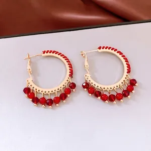 Ethnic style gold hoop earrings with red woven thread and faceted glass bead charms