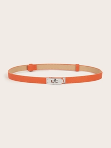 Close-up of orange lychee leather belt with a polished silver metal twist-lock buckle