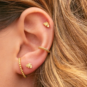 Vintage gold bee stud earrings and beaded ear cuff set shown on a model's ear