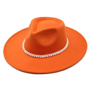 Detailed top view of orange wool fedora hat with elegant white pearl brim decoration