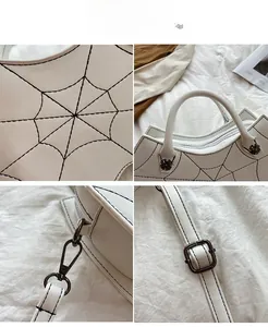 Macro detail of white PU leather bag with black embroidered spider web stitching and hardware