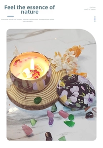 Detailed shot of floral tin candle with dried flower petals on wood base and marble backdrop