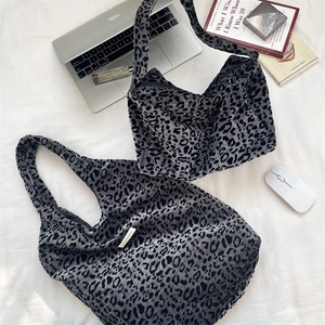 Detail shot of leopard print tote and pouch set with laptop on white fabric background