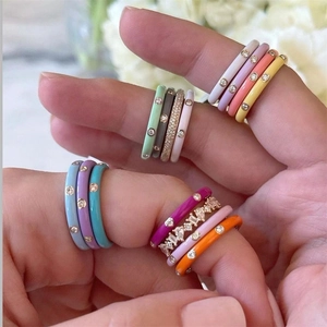 Detailed close-up of colorful enamel stackable rings with sparkling zircon inlay