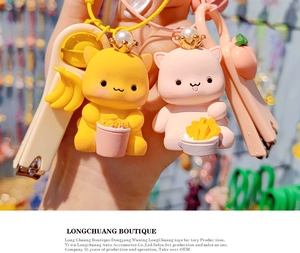 Close-up of cute cat keychains featuring yellow and pink resin kittens with crowns